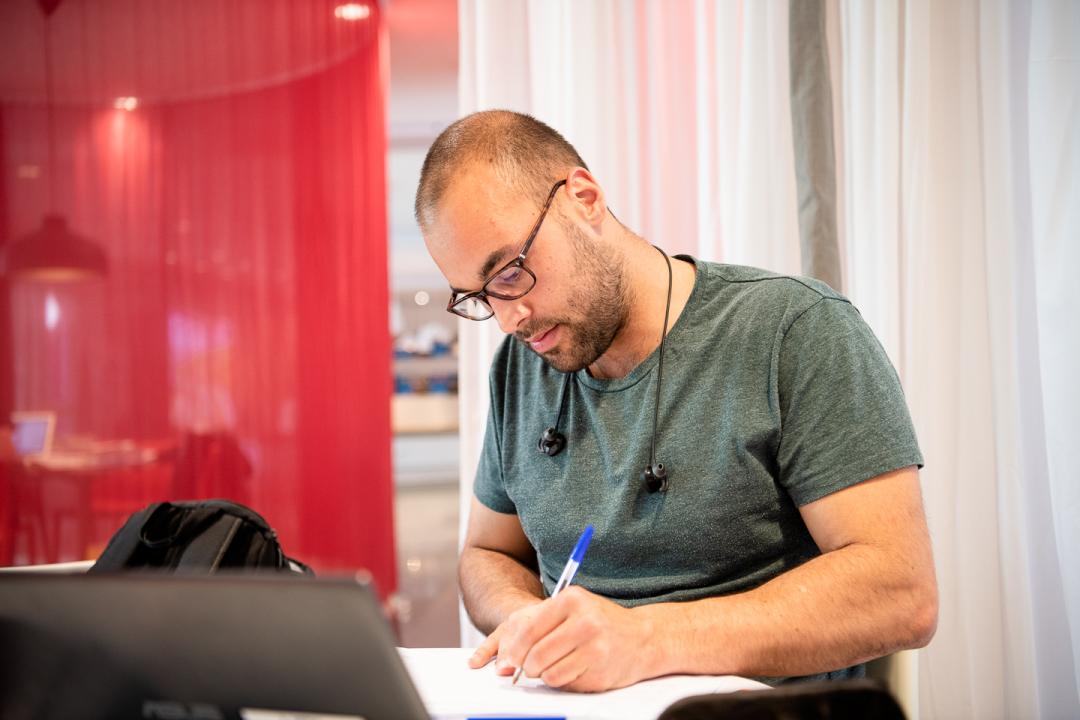 Foto på person som sitter och studerar i biblioteket i Solna.