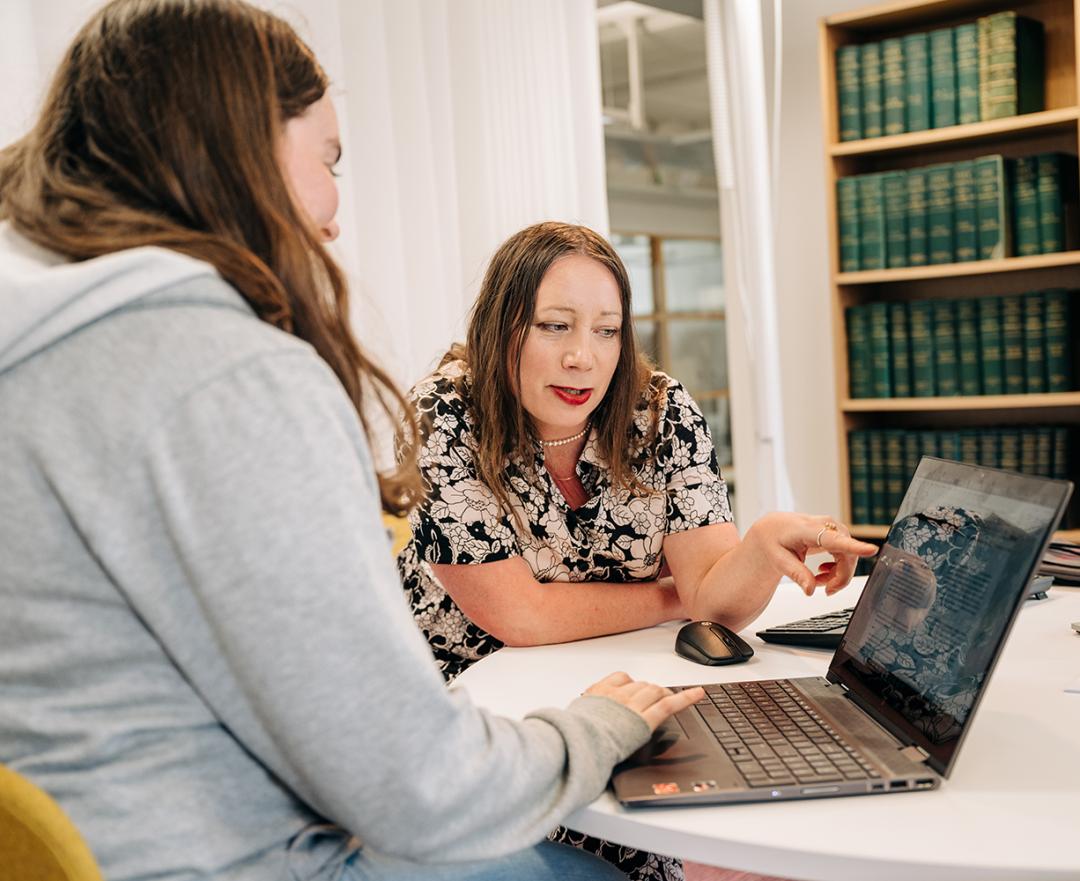 A librarian tutors a student in information searching.