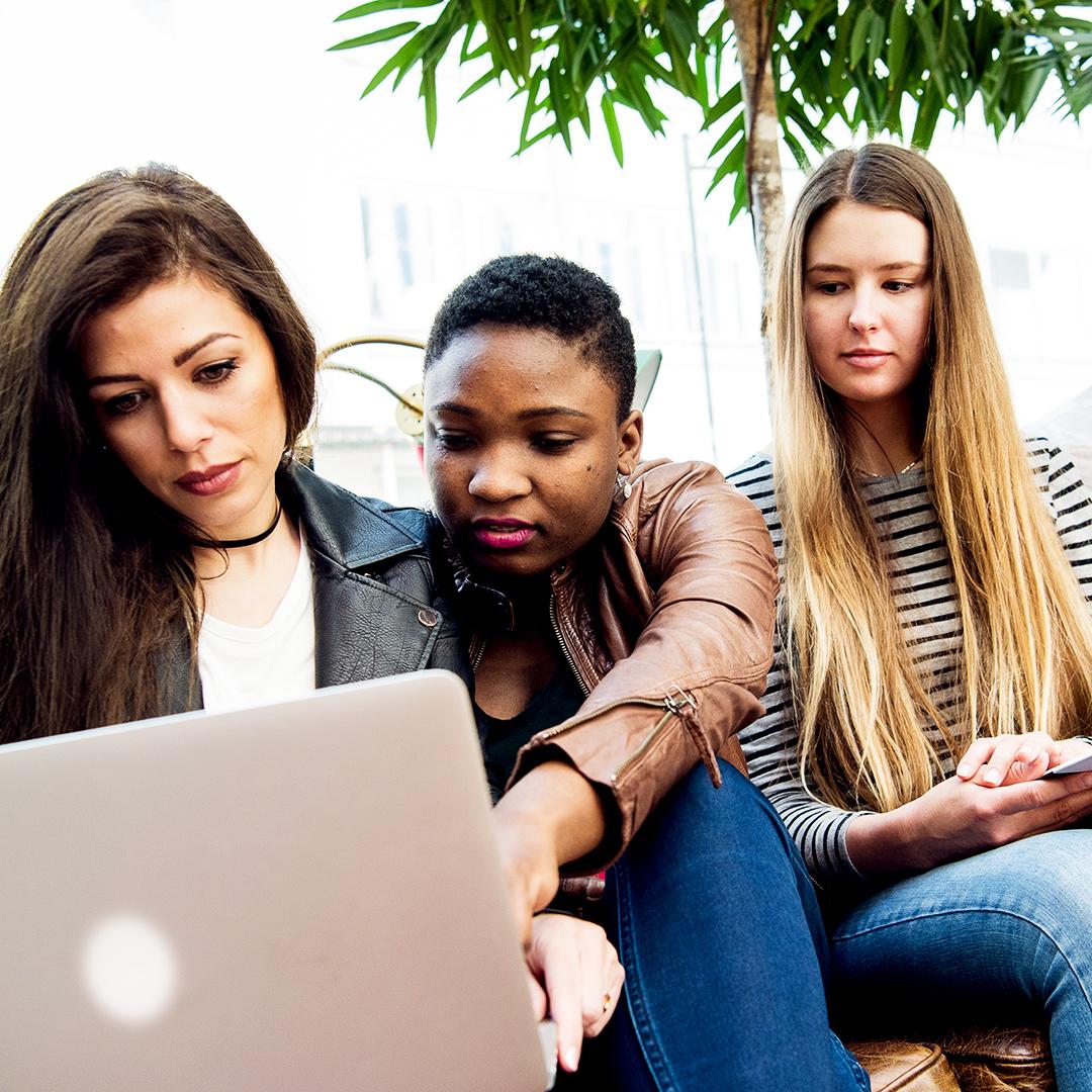 Tre studenter som tittar på en laptop