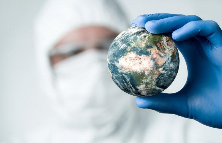 Laboratory worker holding a miniature planet earth