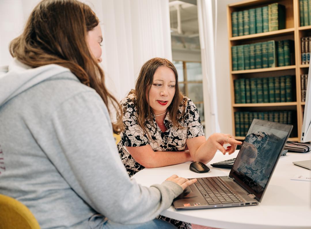 A librarian is guiding a student.